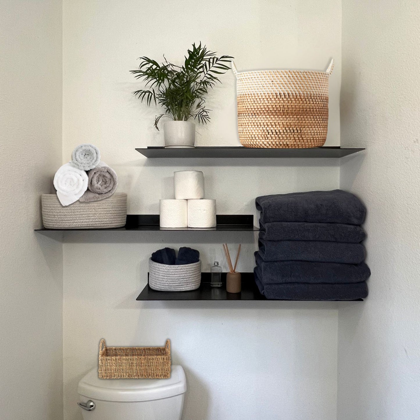 three black bathroom shelves above toilet with decor