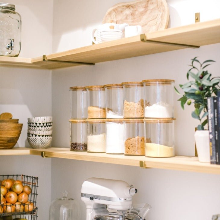 Pantry with wood shelves and brass shelf brackets with clear jars,