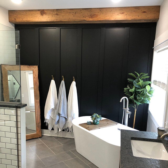 bathroom with black wall and gold towel hooks