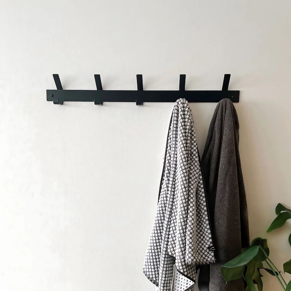 black towel rack on bathroom wall