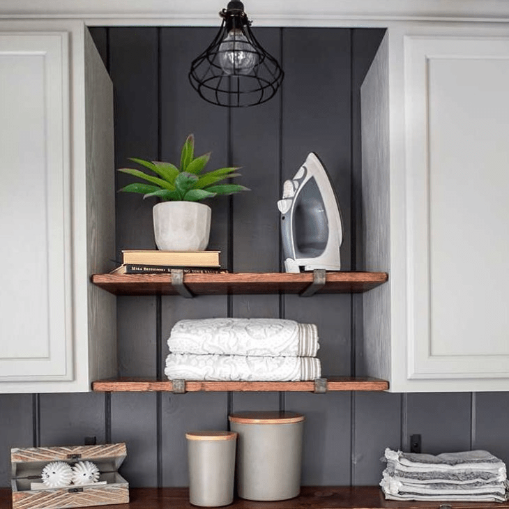 laundry room with two wood shelves made with metal J brackets. White cabinets and neutral decor