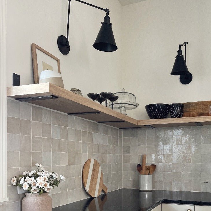 custom kitchen open shelving with heavy duty metal brackets above kitchen backsplash with sconce lighting and decor