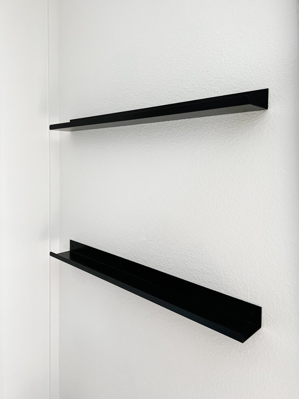 Two black Metal Ledge Shelves mounted on wall