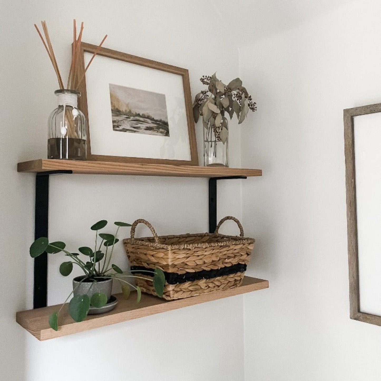 two wood shelves made with metal c bracket with neutral decor