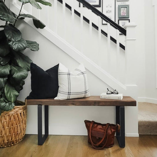 entryway with wood bench and metal legs with pillows, bags, and decor
