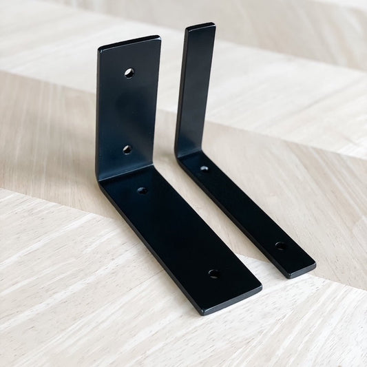 Two metal black 90 degree angle L brackets one is 2" wide and the other is 1" wide