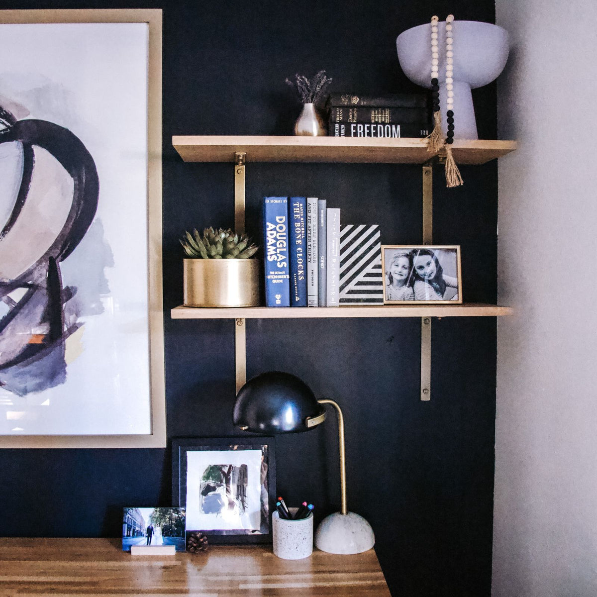 black office wall with wood shelves and gold brackets