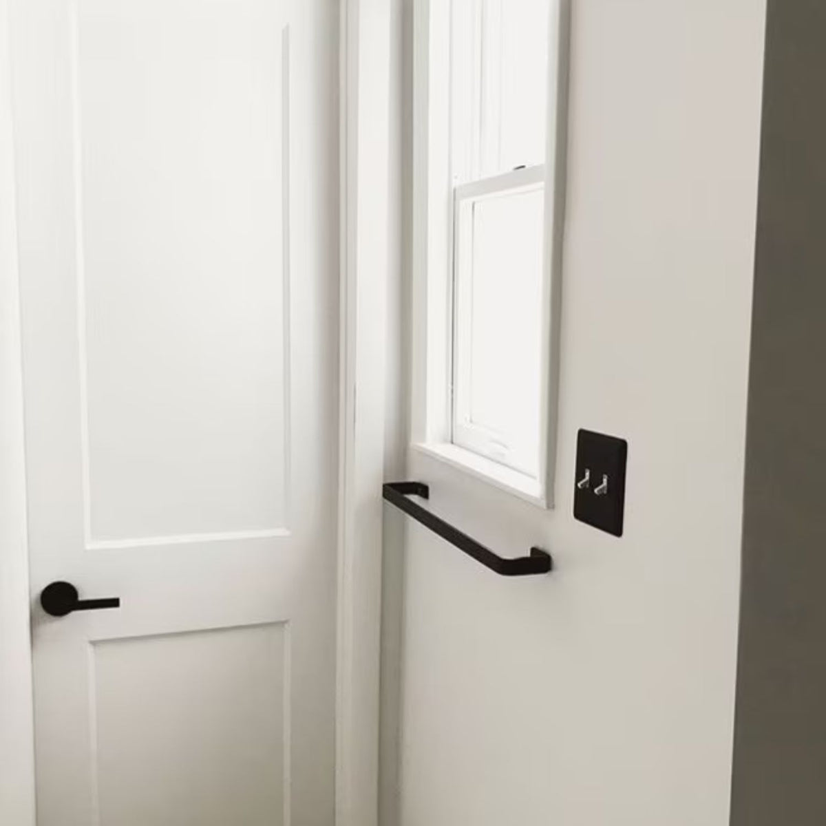 white bathroom with black towel bar