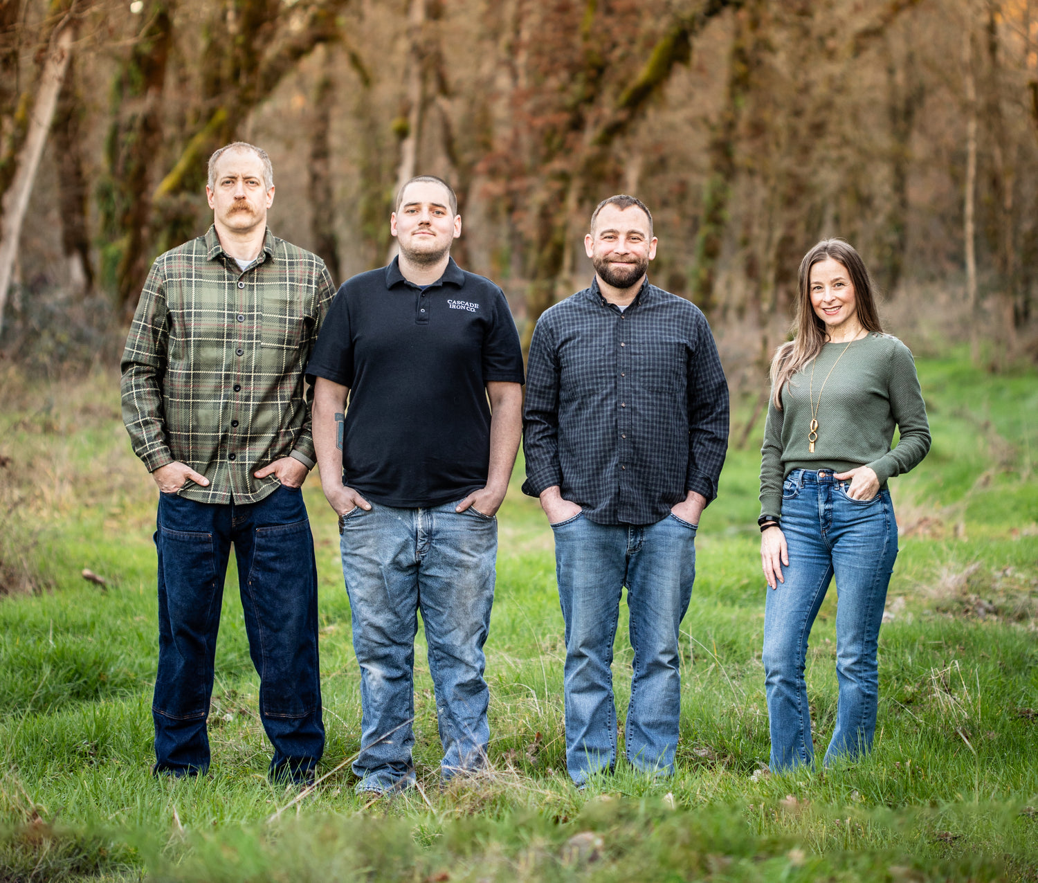 cascade iron co team of four people standing in a grassy field with trees in the background