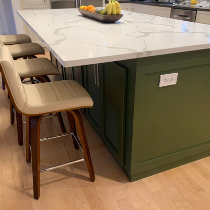 green kitchen island with marble countertop and bar stools