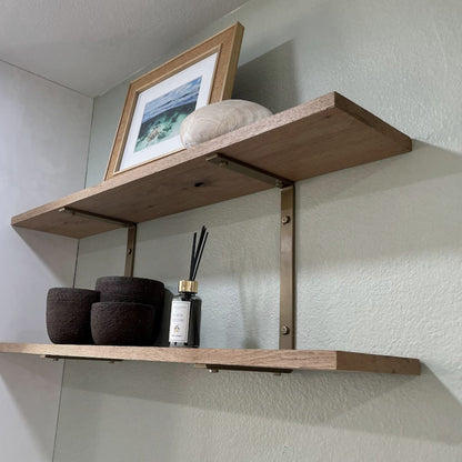 two wall shelves with brass brackets 