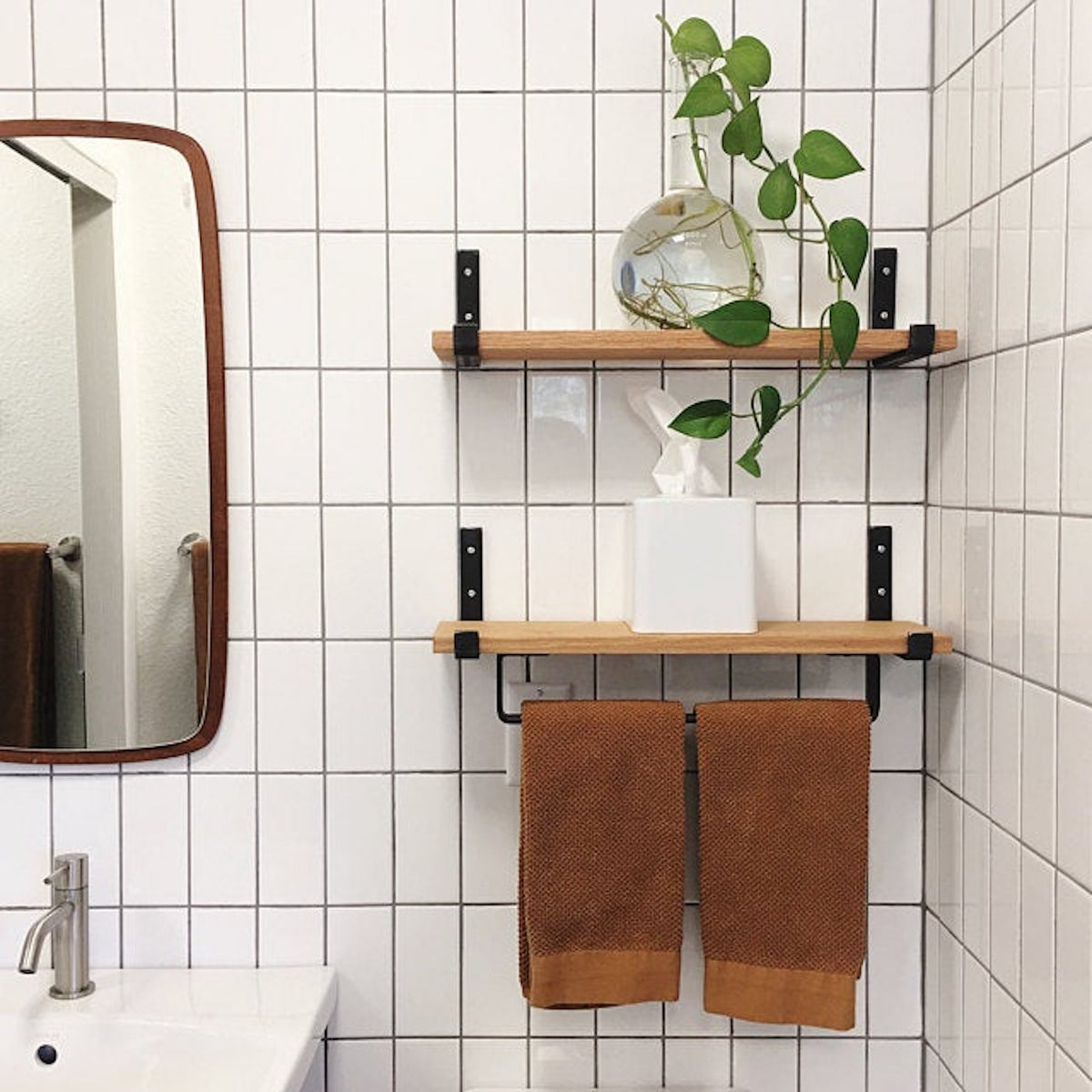 bathroom with white tile and wood shelves