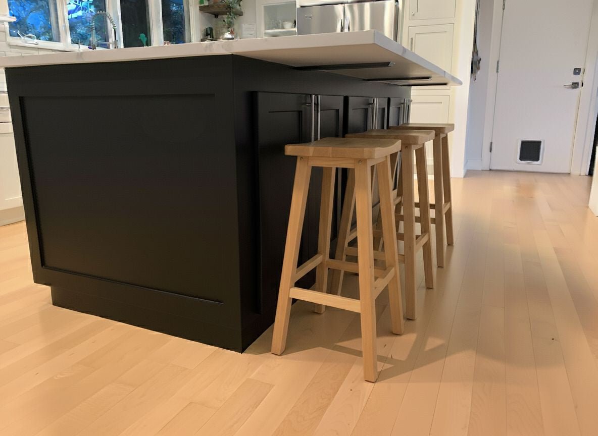 kitchen island with black cabinets and hidden countertop supports under overhang