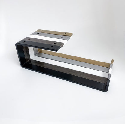 Five under mount metal paper towel holders with open arm and front lip lined up in black, white, silver, brass, steel