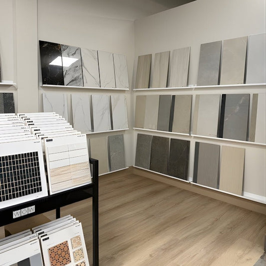 Interior design store with stone tiles displayed on three rows of white wall mounted metal shelf ledges.