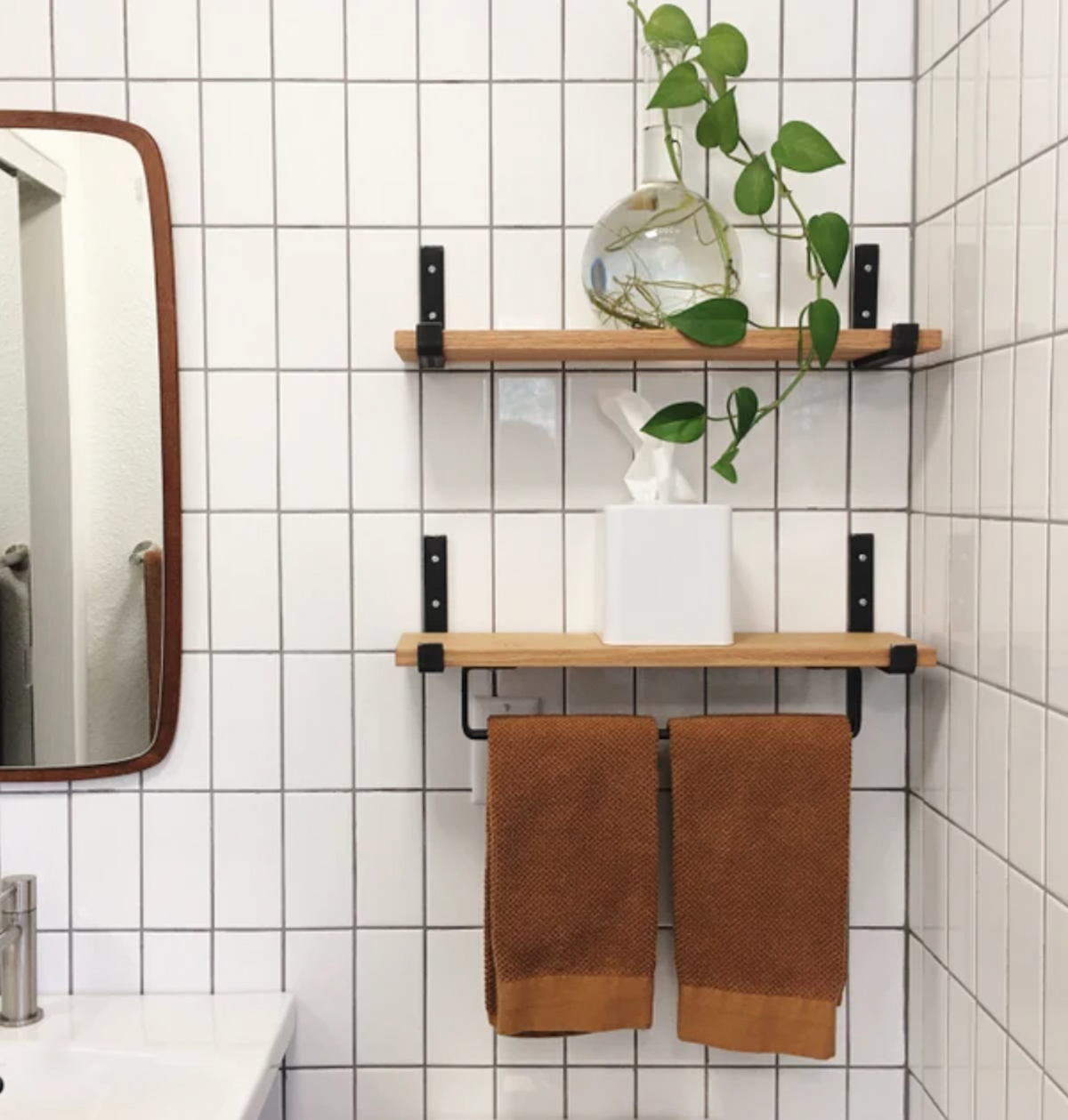 bathroom shelves with black towel rack