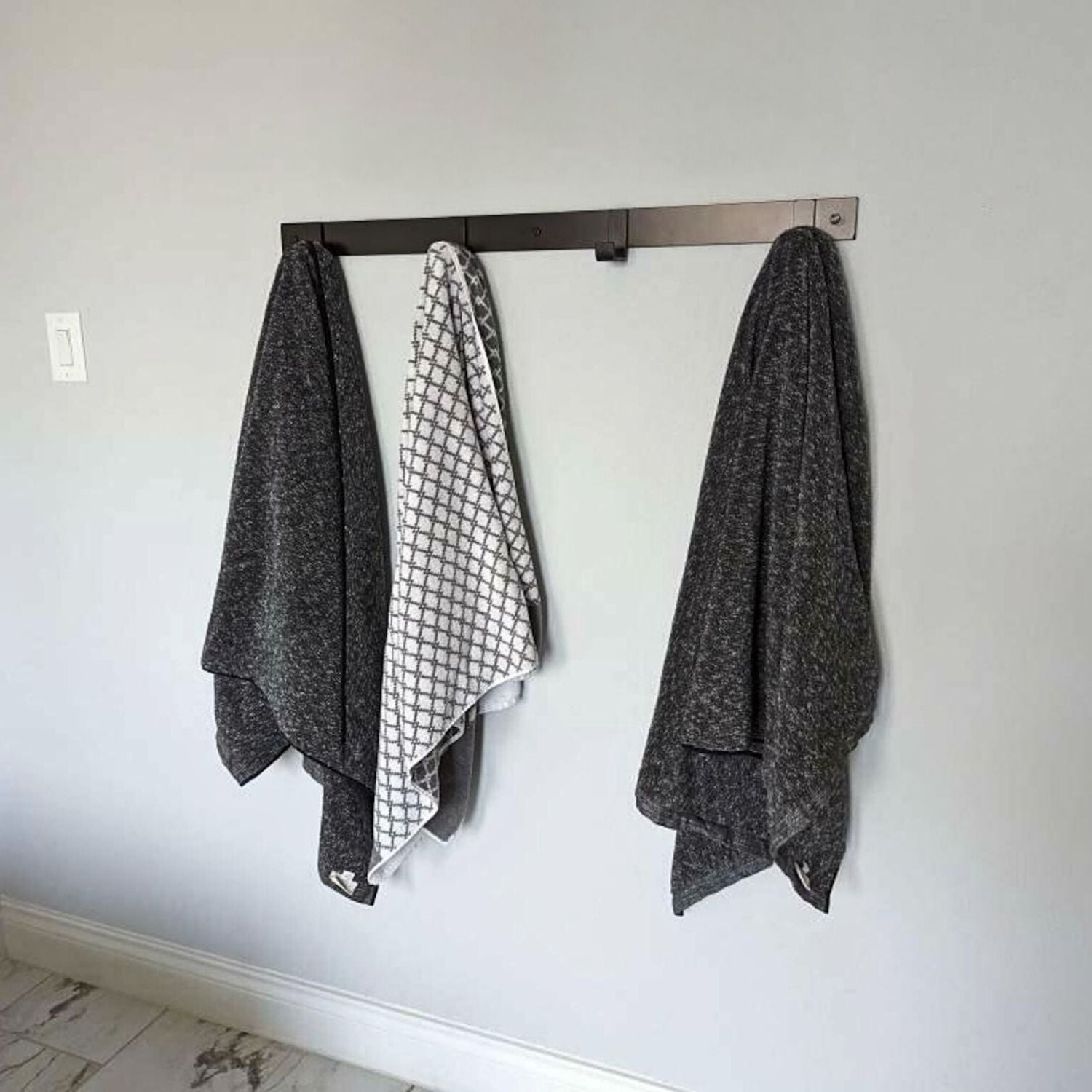 bathroom with towels hanging on black rack